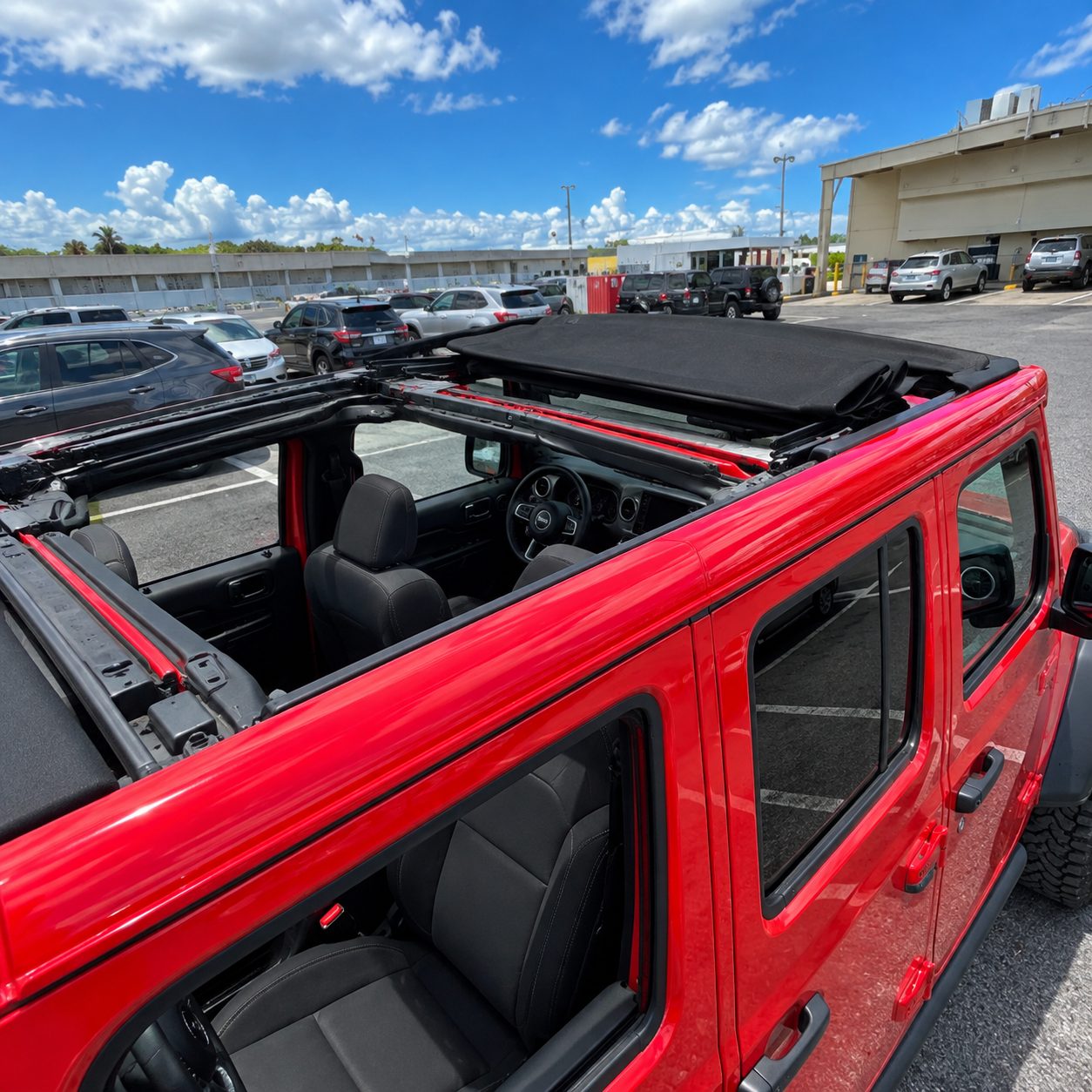 Soft top folded back on the red Jeep Willys showing the open-air interior and rear seats