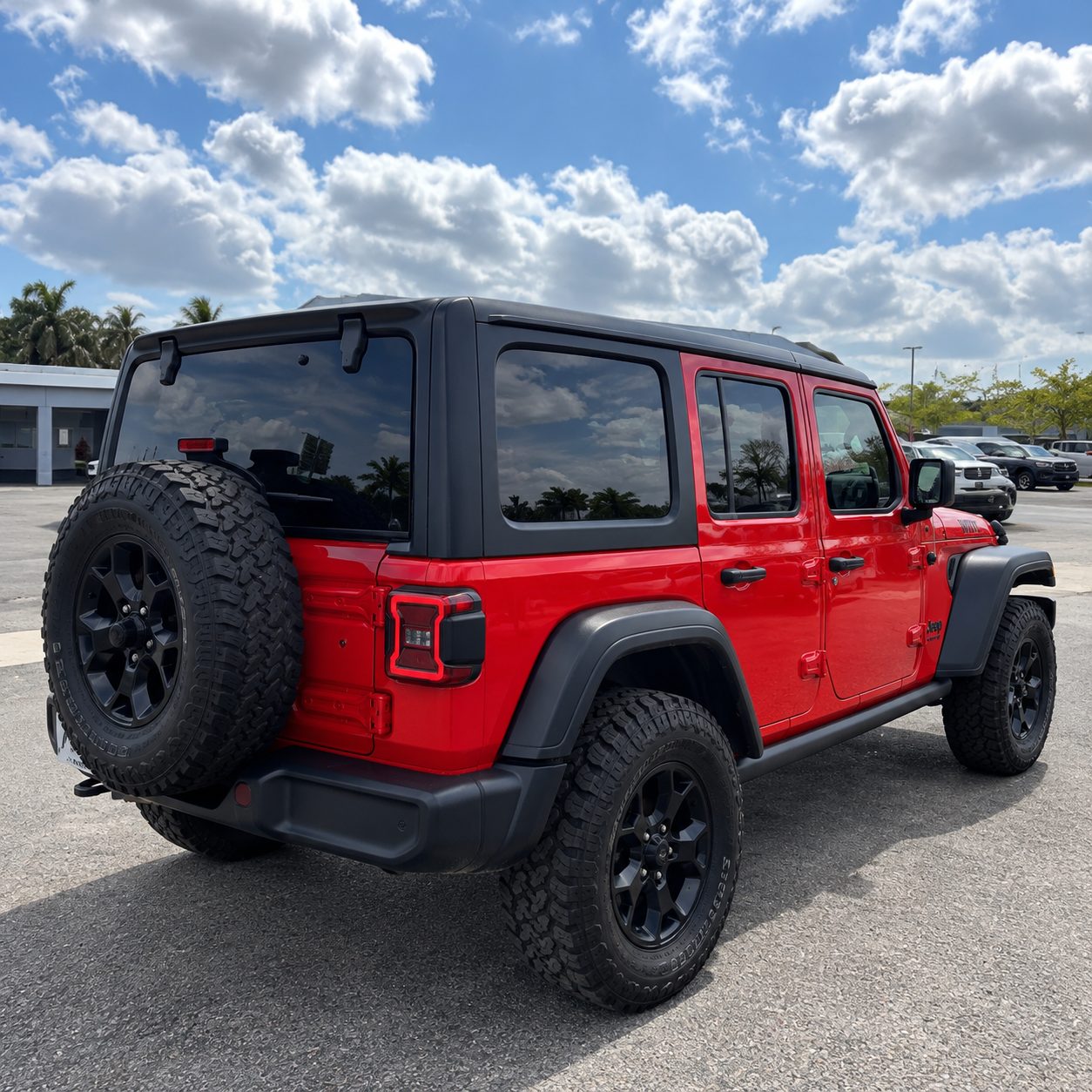 Big Red Jeep Wrangler Willys rear view with spare tire and hard top