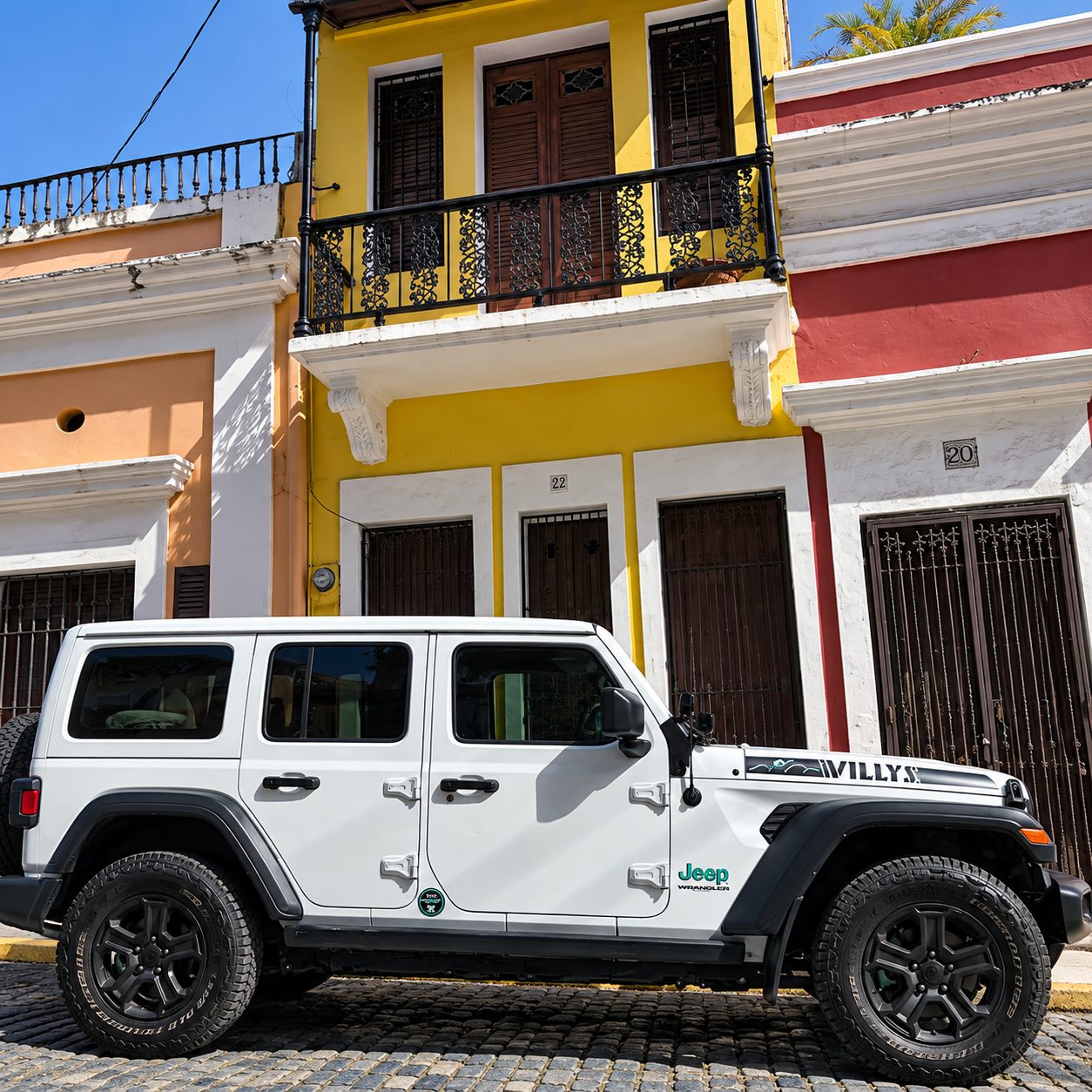 Side profile of the white Jeep Willys on a cobblestone street in Old San Juan