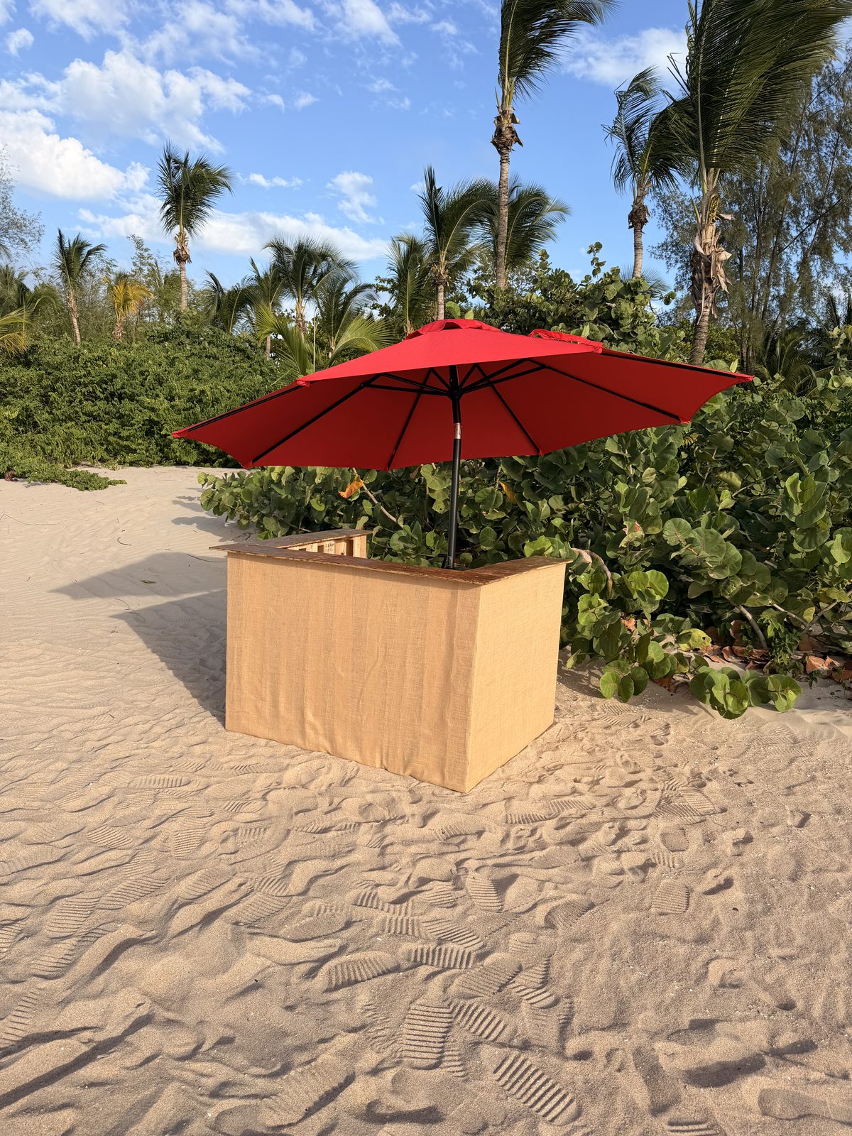 Jet ski rental kiosk with a red umbrella on the sand at Pine Grove beach, the meeting point in Isla Verde, Puerto Rico