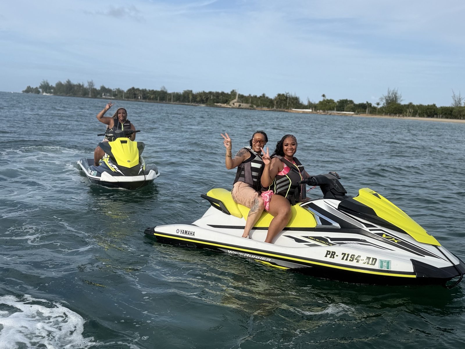 Group of riders on two Yamaha jet ski rentals along the shoreline in Puerto Rico