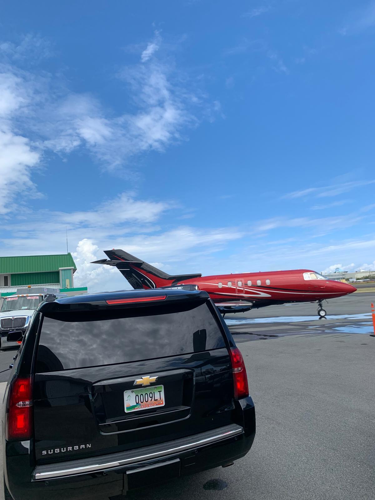 Luxury SUV next to a private jet at a Puerto Rico airport