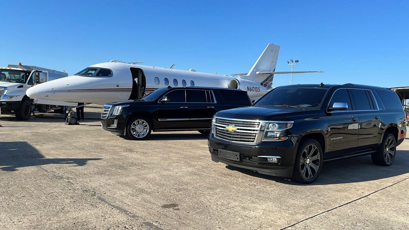 Luxury SUV and limousine alongside a private jet